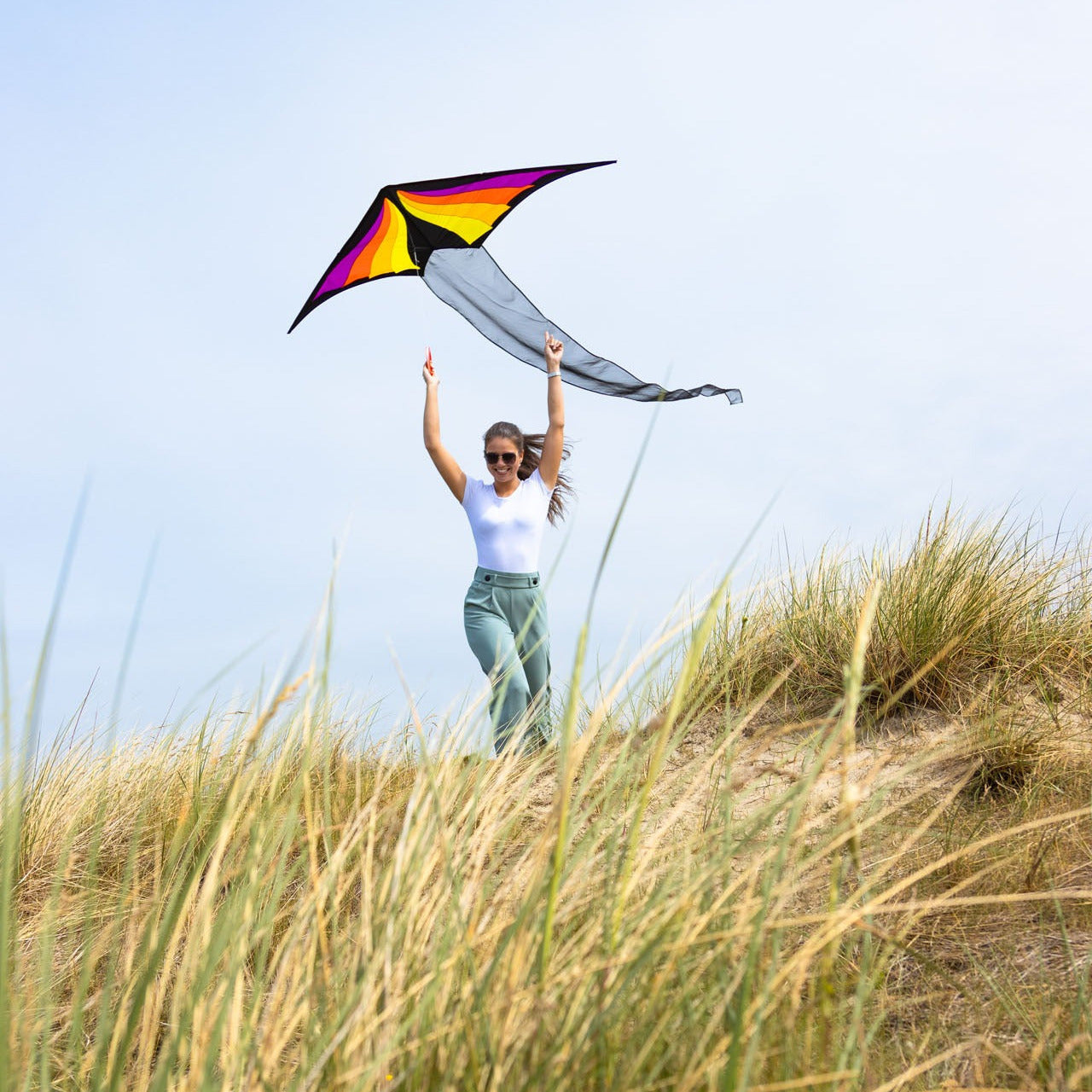 Person flying a colorful kite on a beach