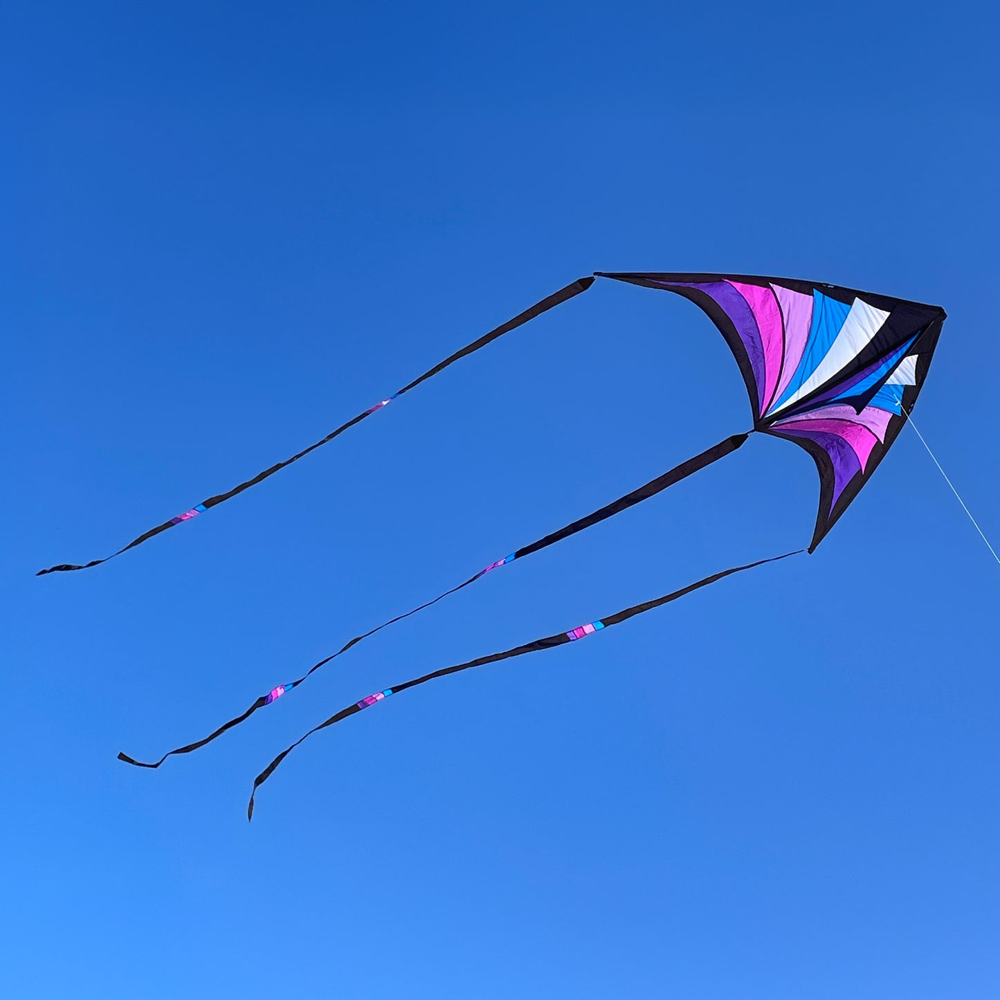 Colorful kite flying against a clear blue sky