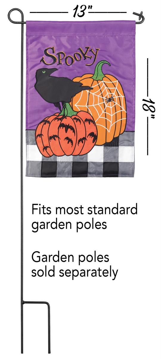 A Halloween garden flag with a purple background, orange pumpkins, a black raven, and the word 'Spooky' in script. The flag is shown hanging from a black metal pole on a white background, with text indicating dimensions and that the poles are sold separately.