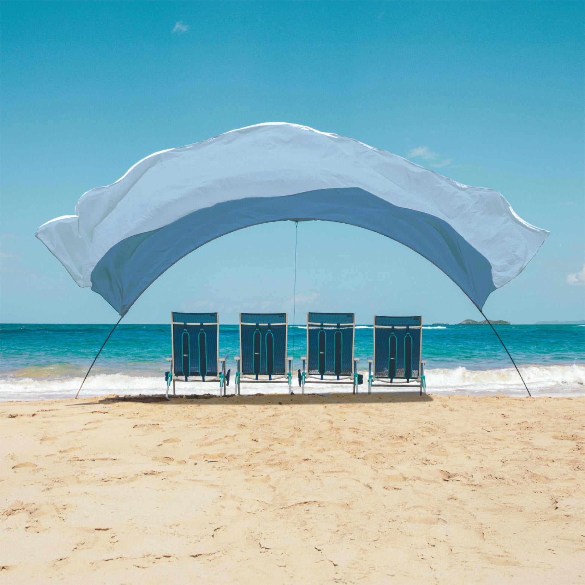Beach shade on a sandy beach with ocean and clear blue sky in the background