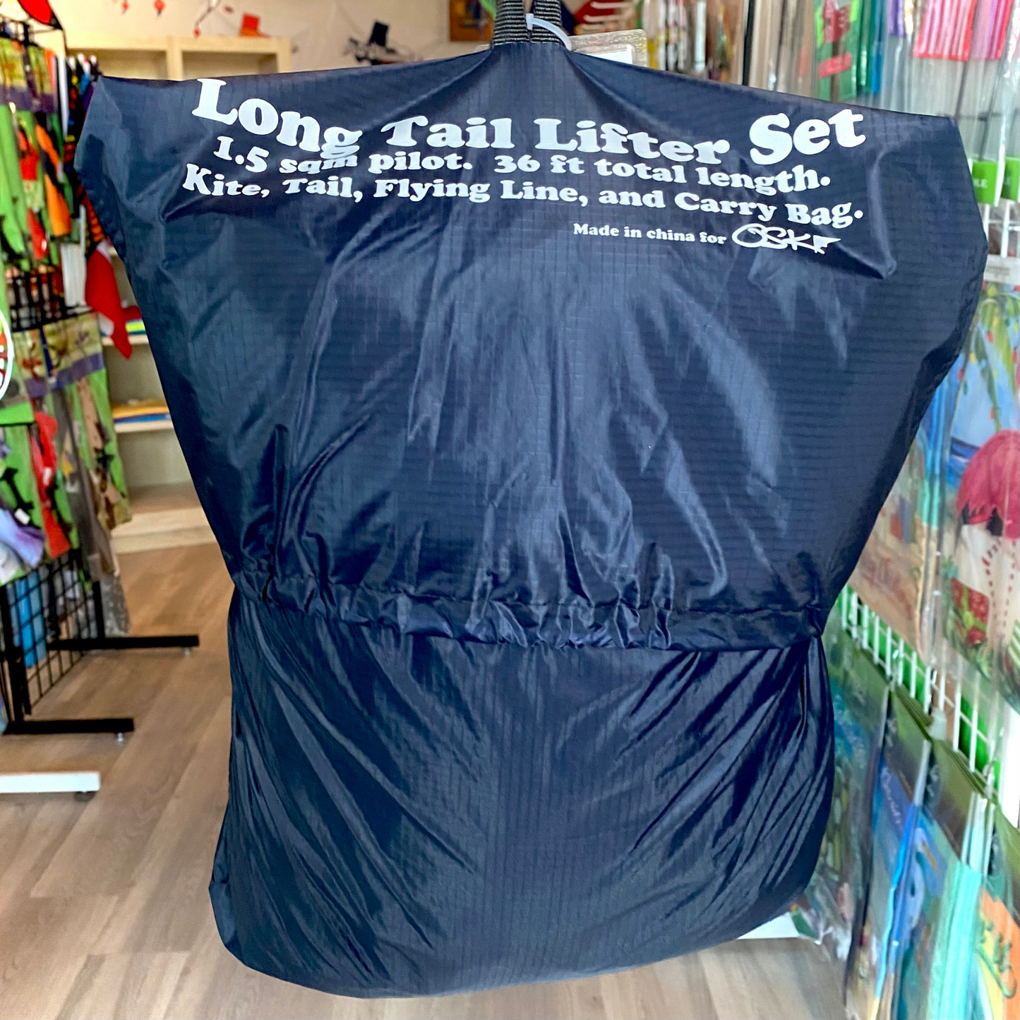 Black storage bag with text on a hanger in a store setting
