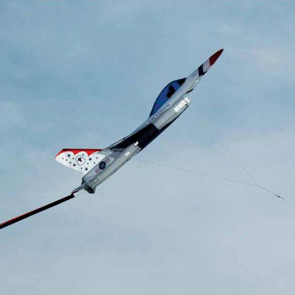 Jet shaped kite flying against a blue sky