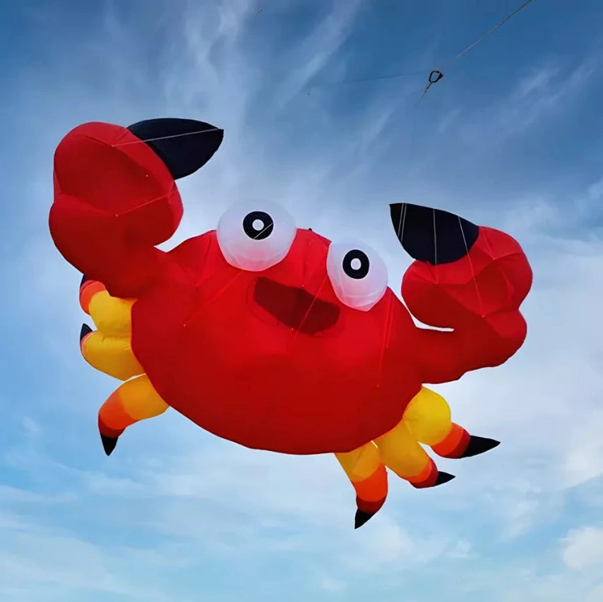 Red crab-shaped kite flying against a blue sky with white clouds