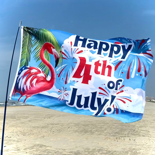 Flag with 'Happy 4th of July!' text and flamingo design on a beach.