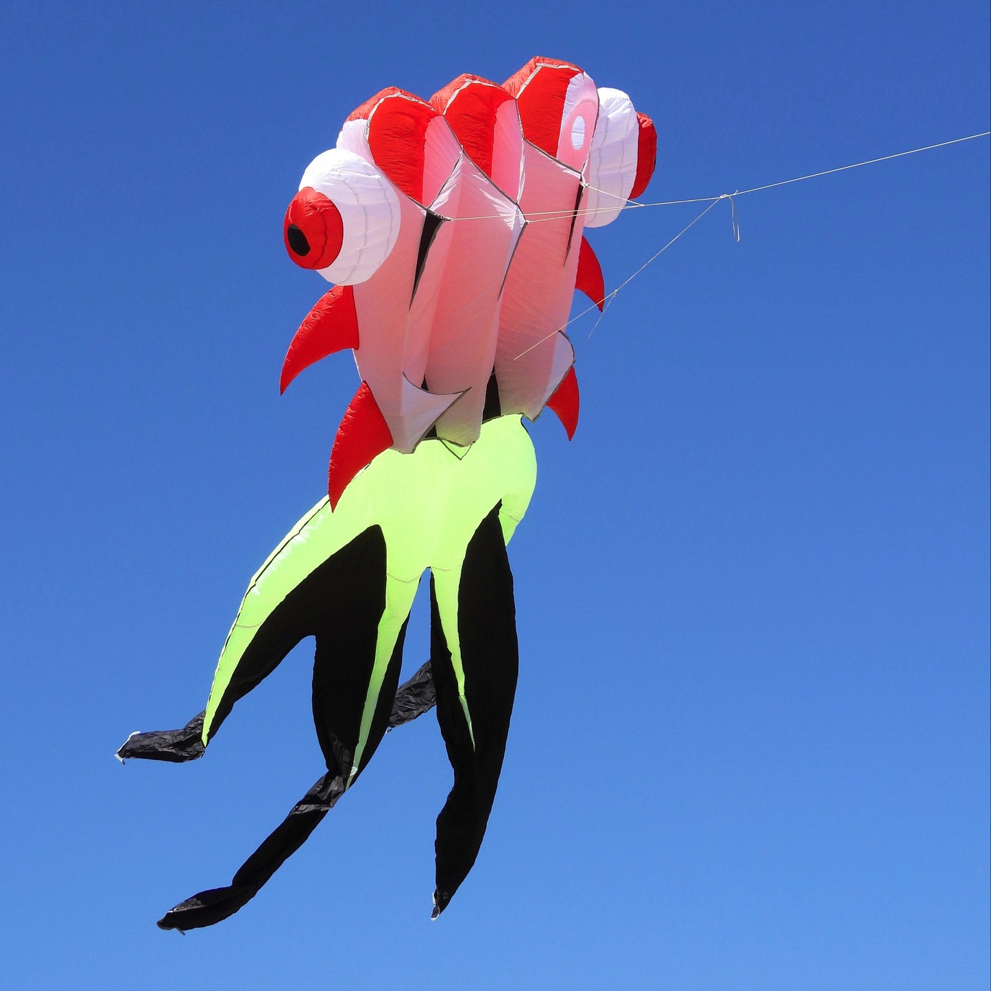 Colorful fish-shaped kite flying against a clear blue sky