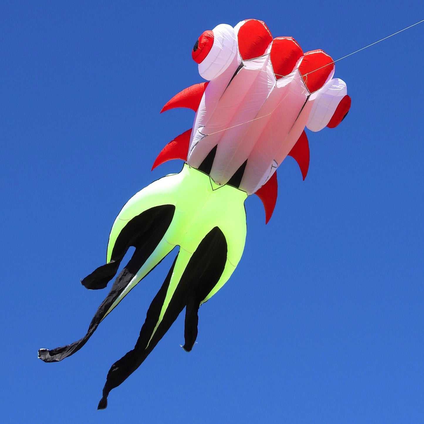 Colorful kite shaped like a fish against a clear blue sky