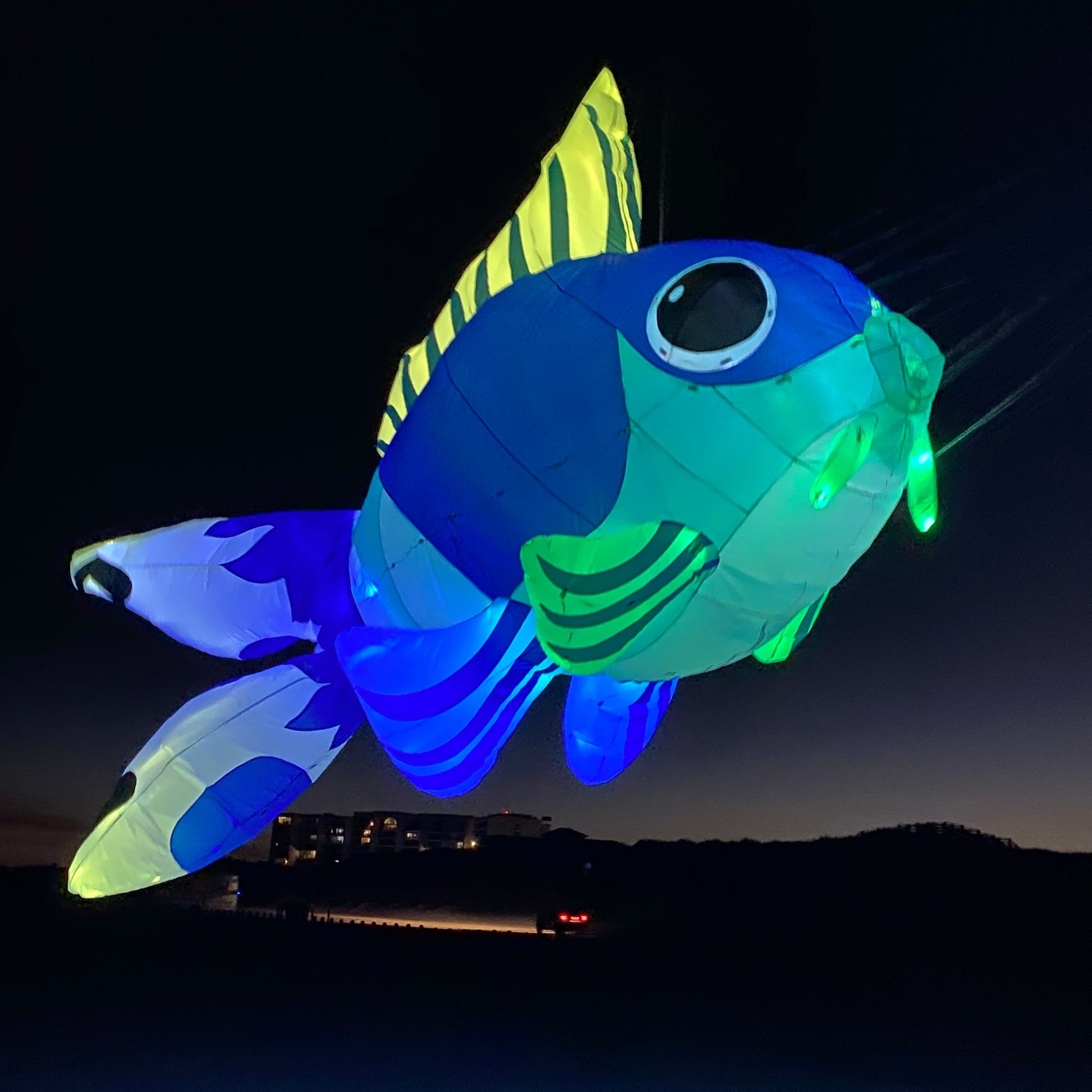 Goldfish with glowing green and blue colors on a dark background