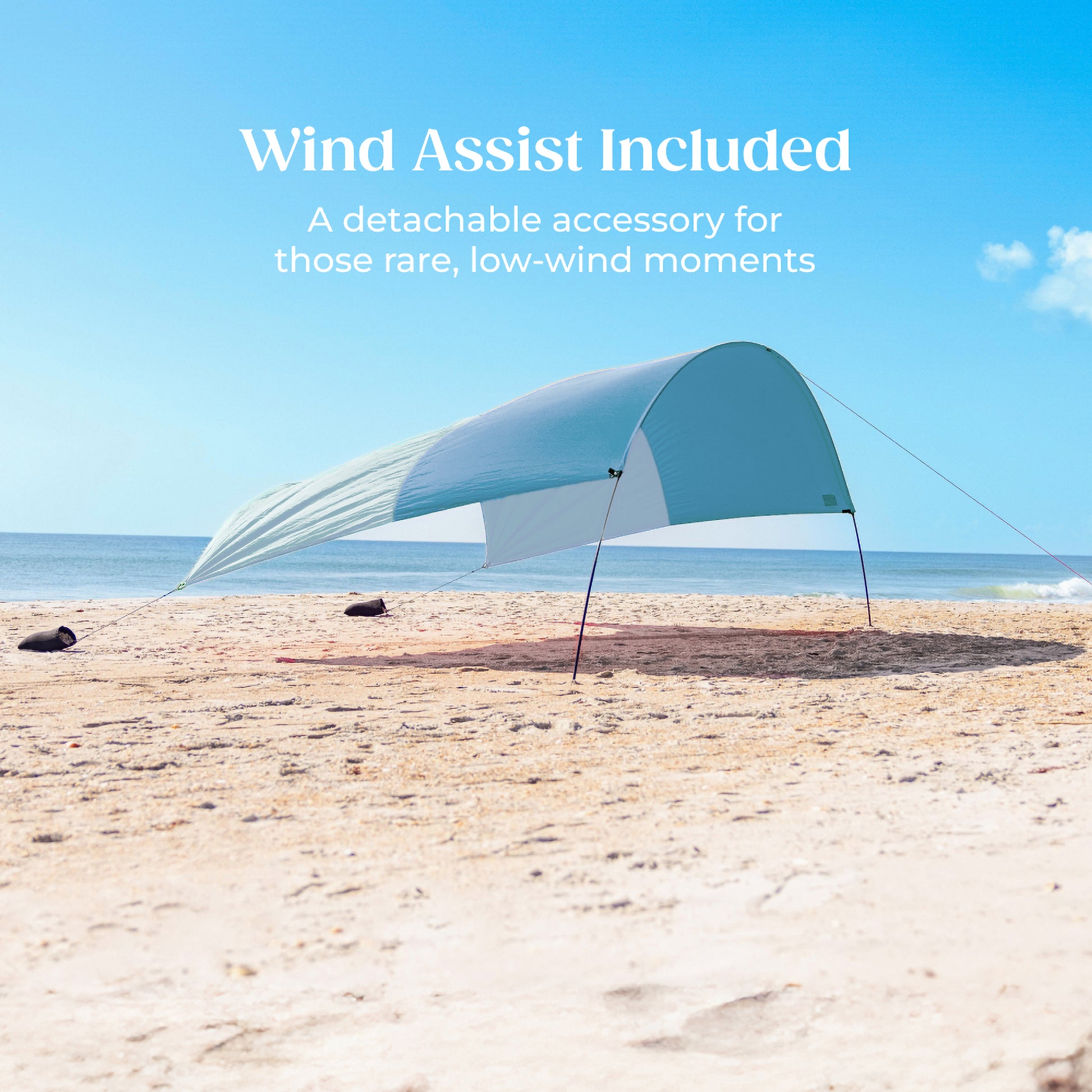 Beach shade with wind assist feature on a sandy beach with ocean view