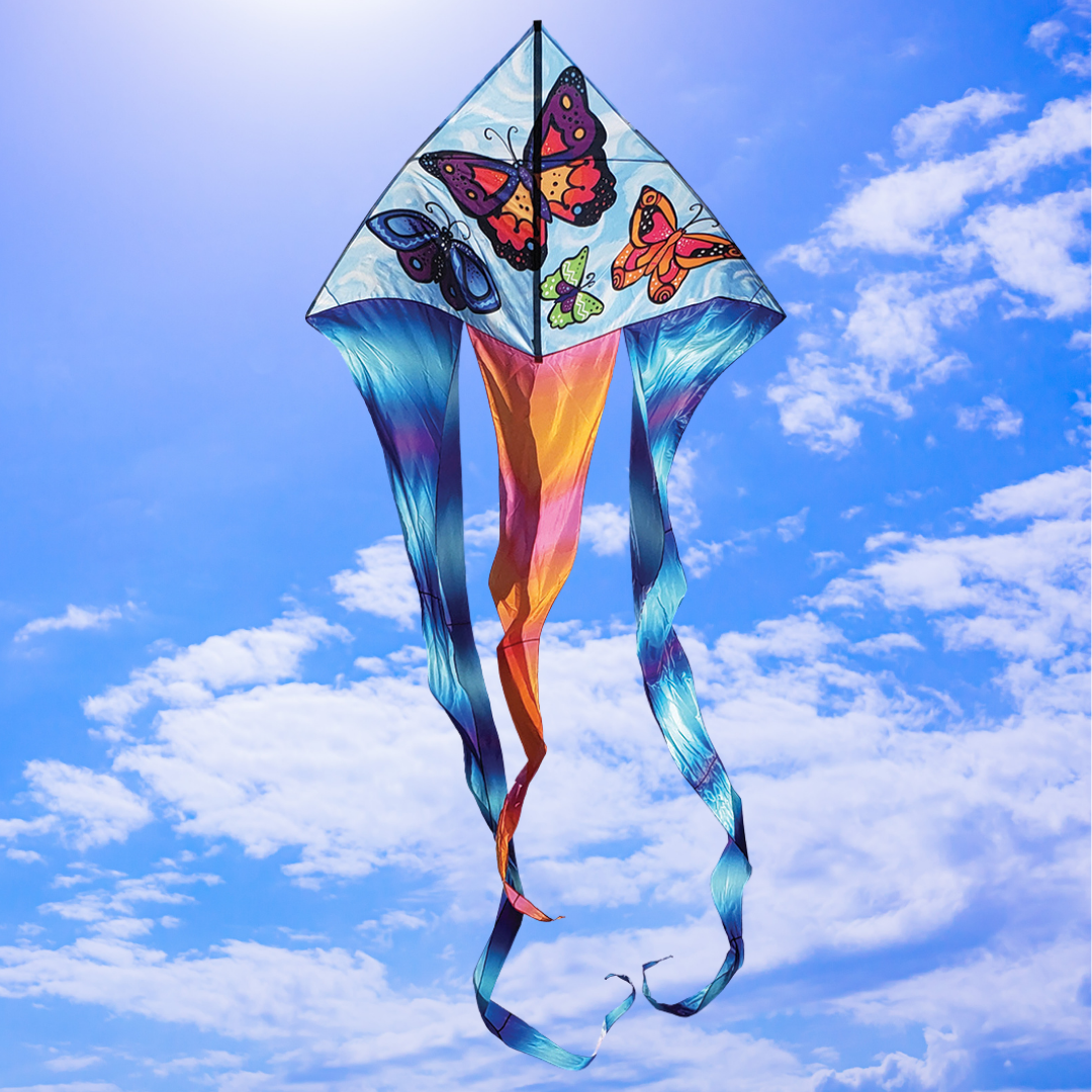 Colorful kite with butterfly designs against a blue sky with clouds