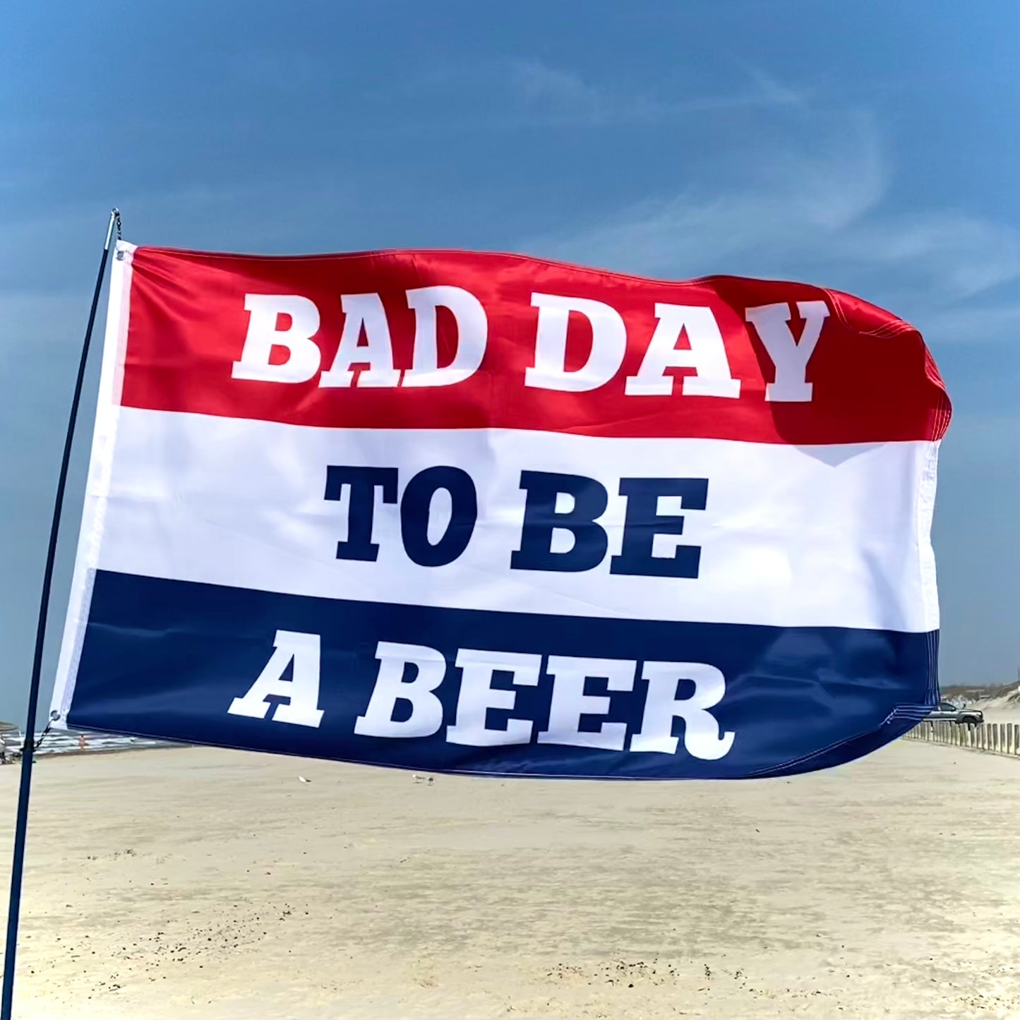 Flag with 'Bad Day to Be a Beer' text against a clear sky