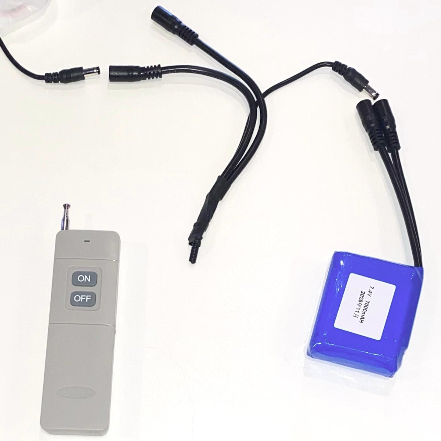 Blue battery pack with cables and a remote control on a white background.