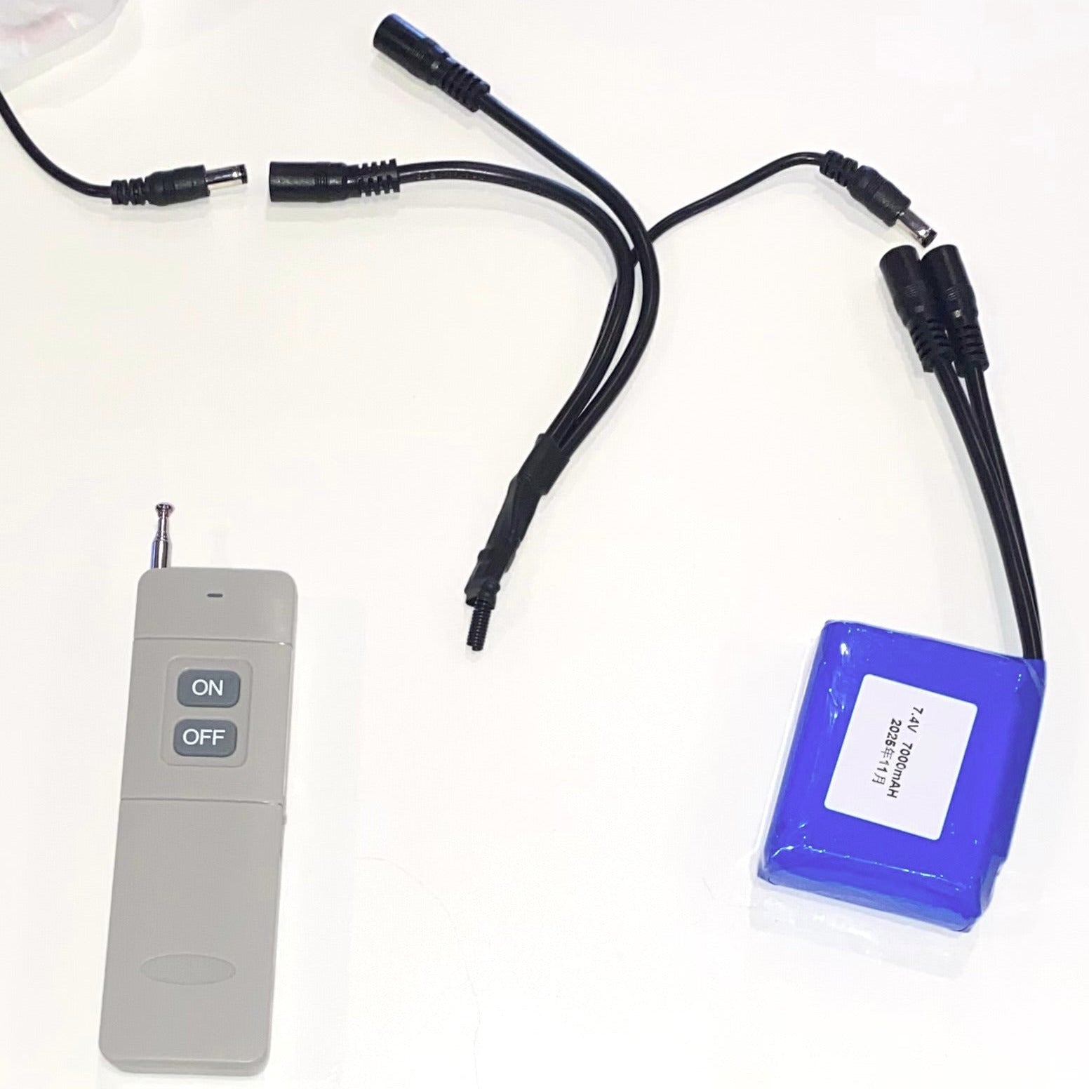 Blue battery pack with cables and a remote control on a white background.