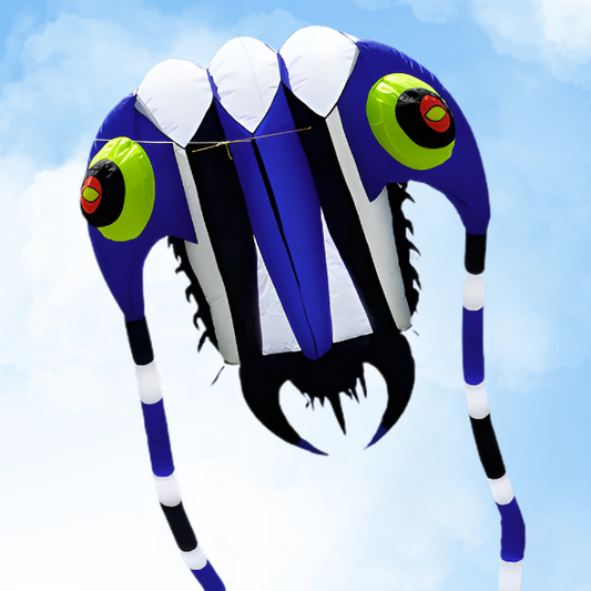 Colorful trilobite kite with blue, black, and white design against a clear sky