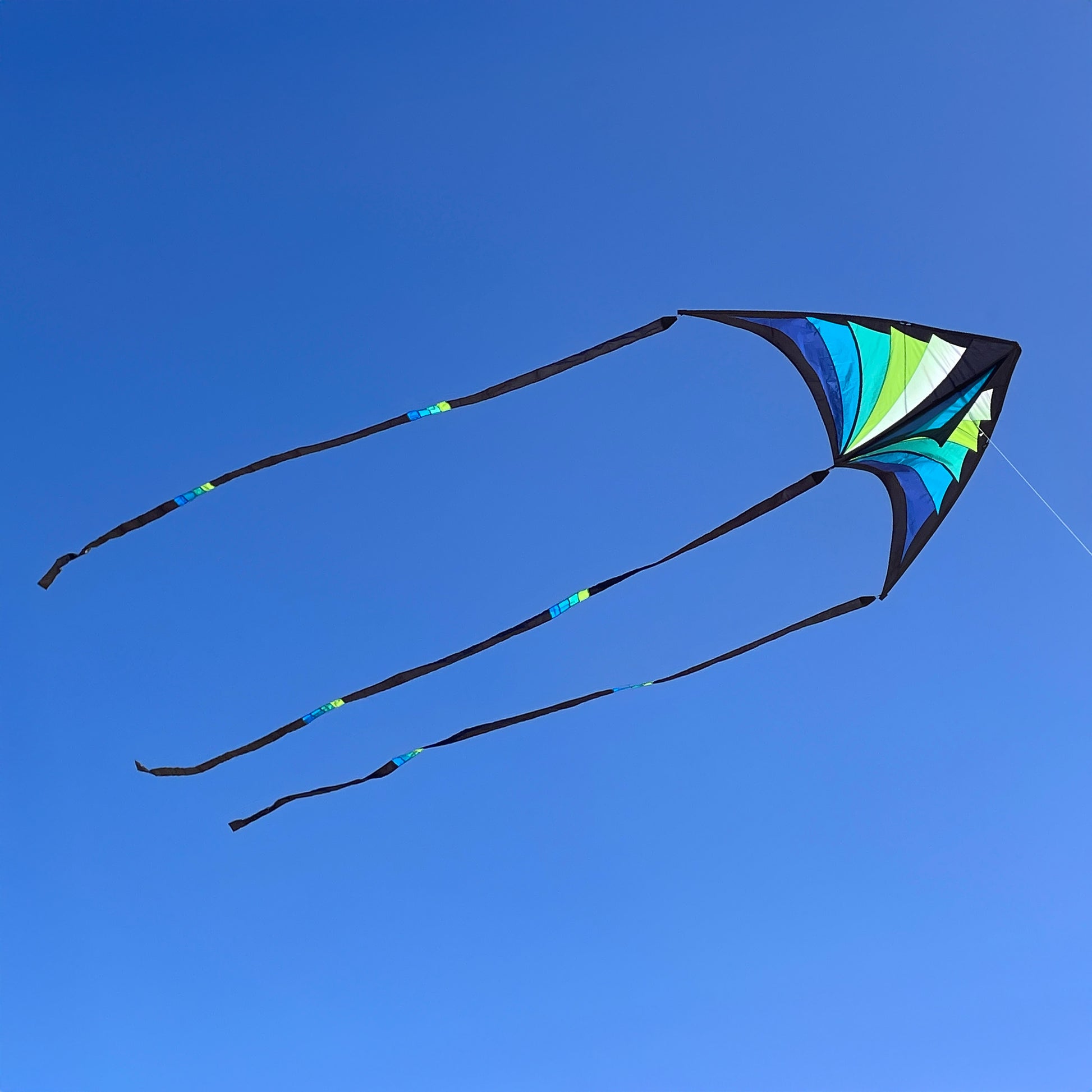Colorful kite with long tails against a clear blue sky