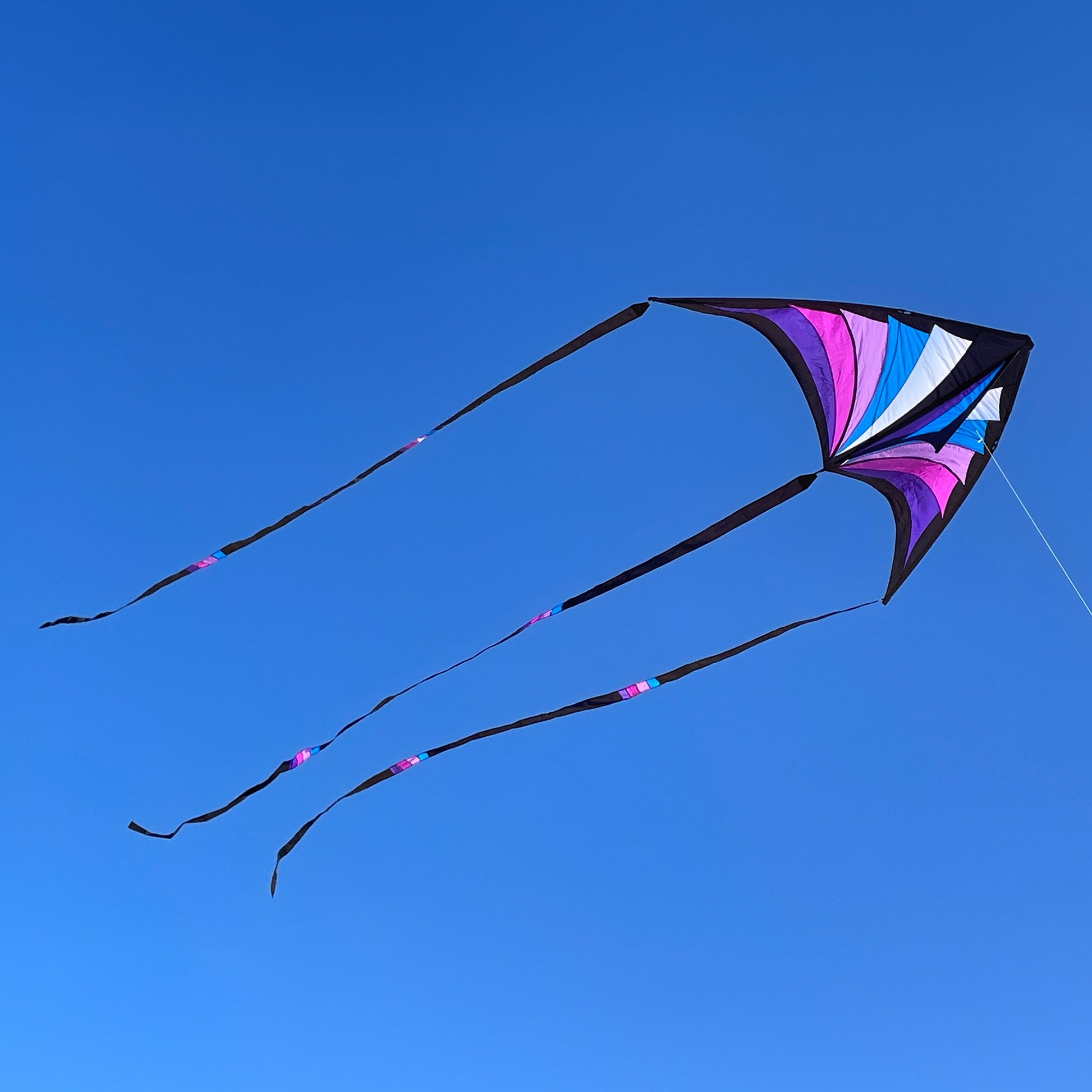 Colorful kite flying against a clear blue sky