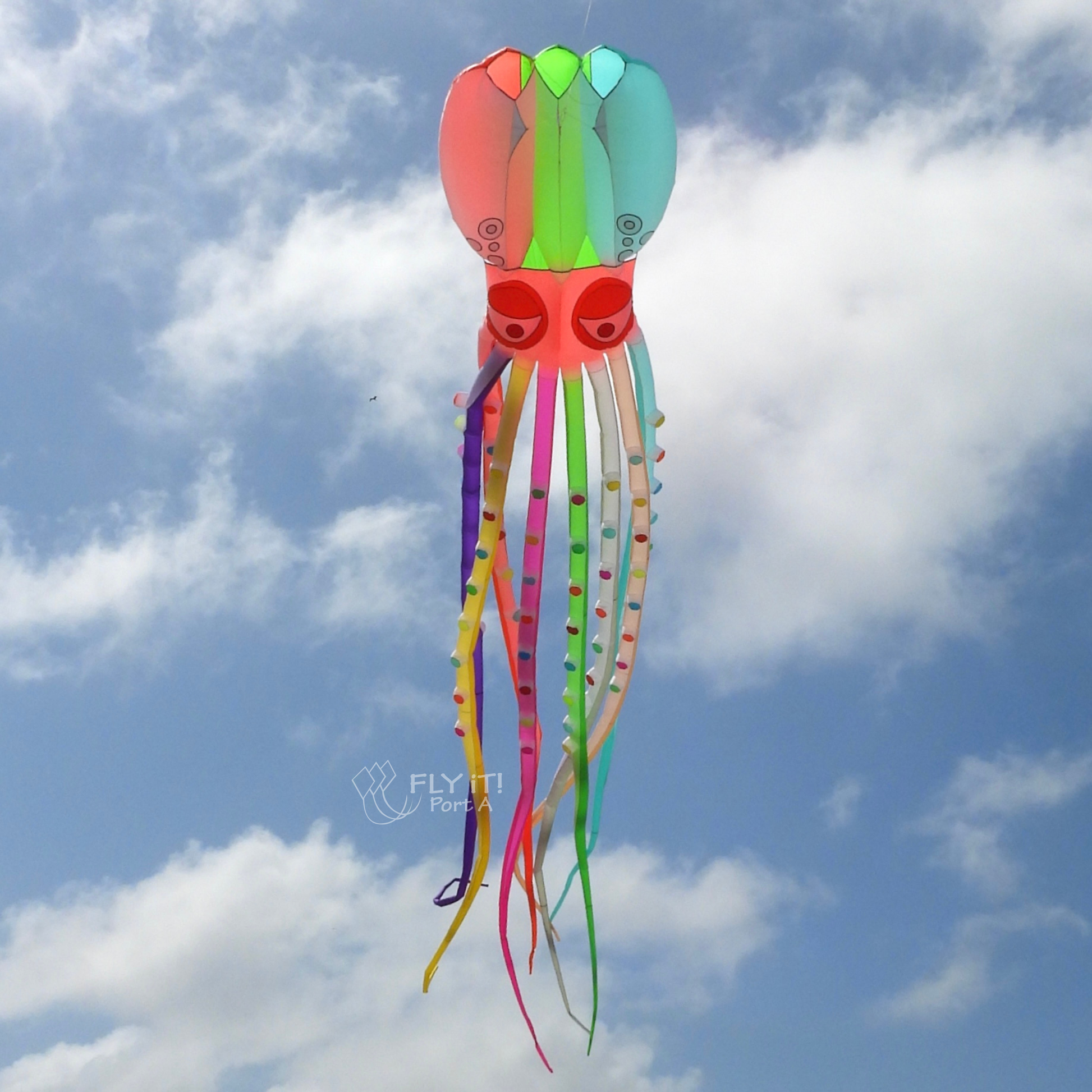 Colorful octopus-shaped kite flying against a blue sky with clouds