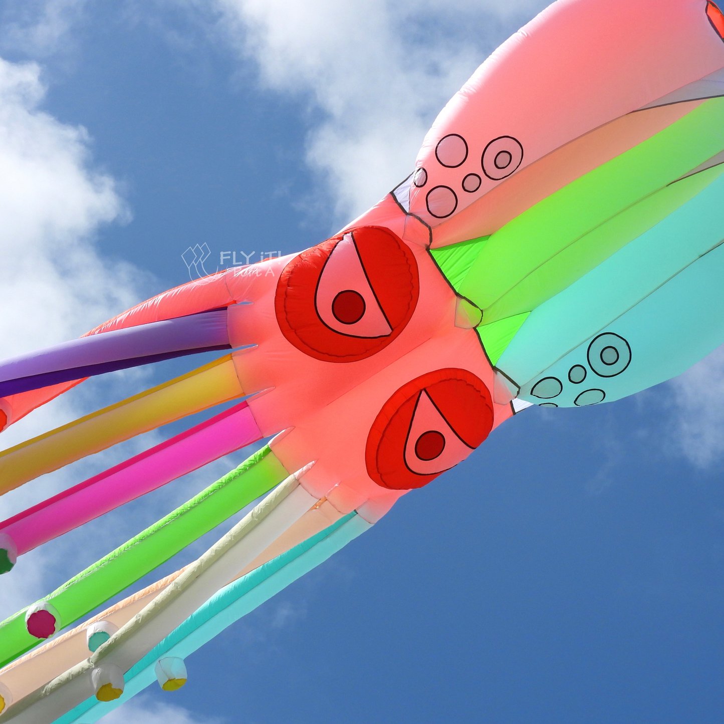 Colorful kite with red face design against a blue sky
