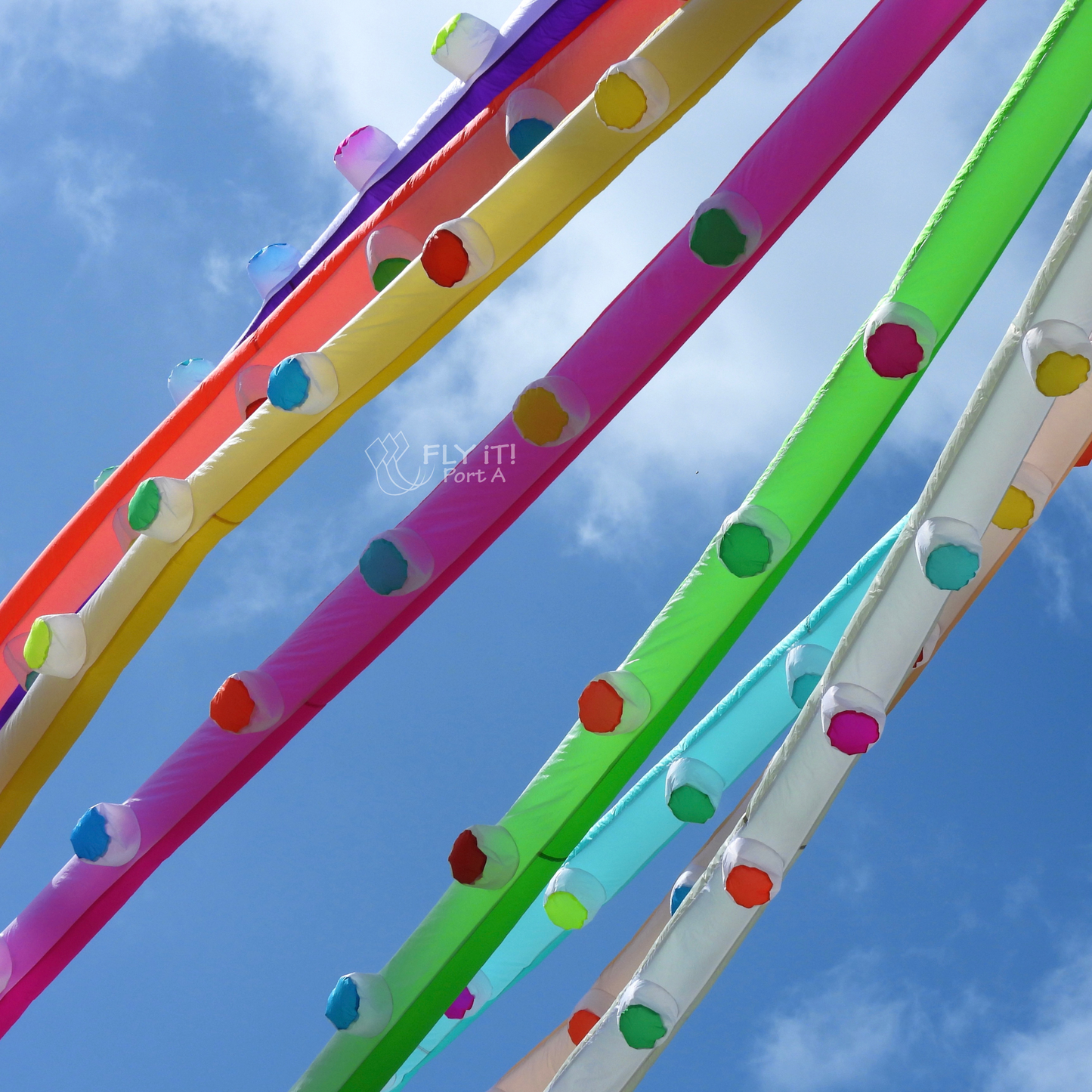 Colorful octopus kite legs against a blue sky .