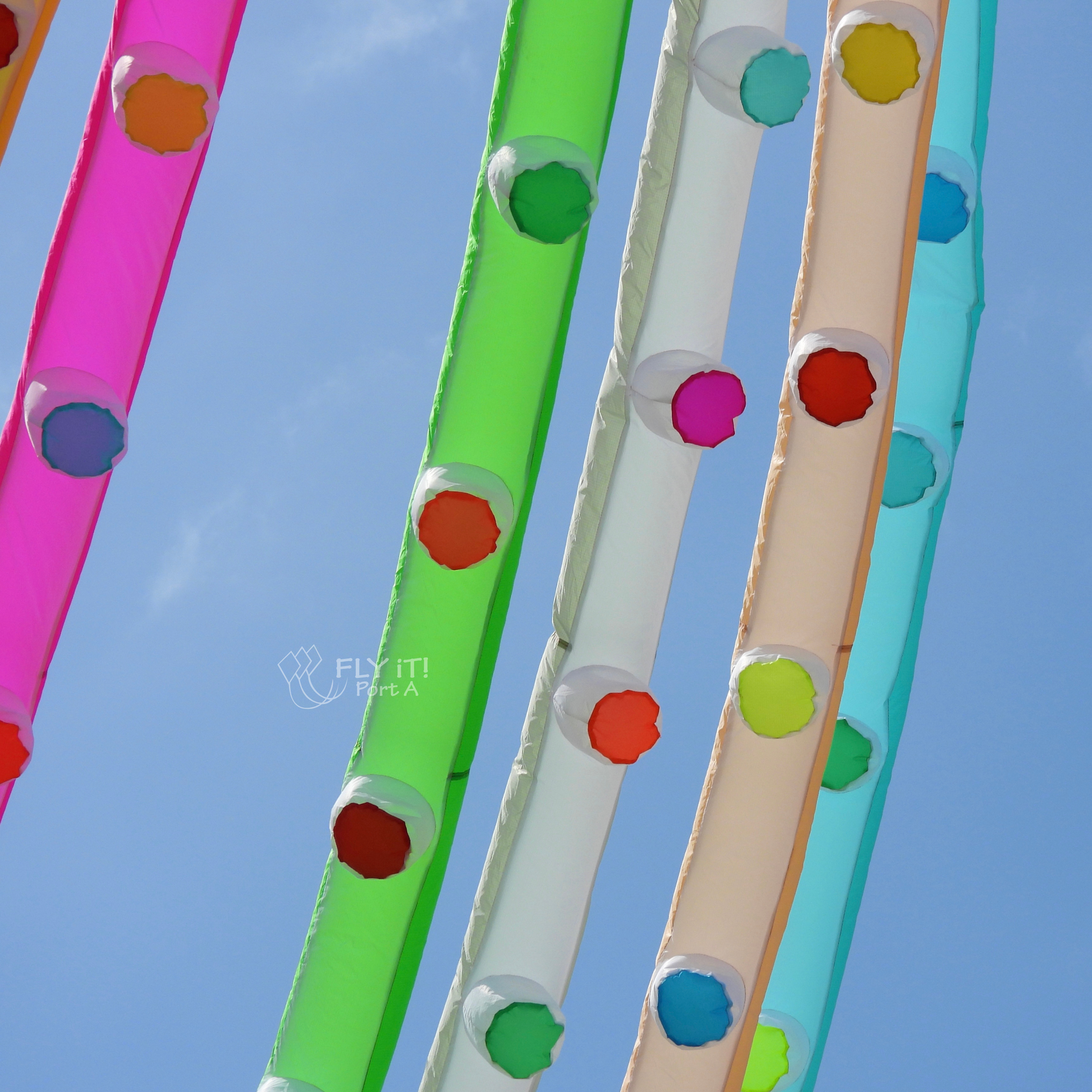 Colorful octopus kite legs with colored dots against a blue sky