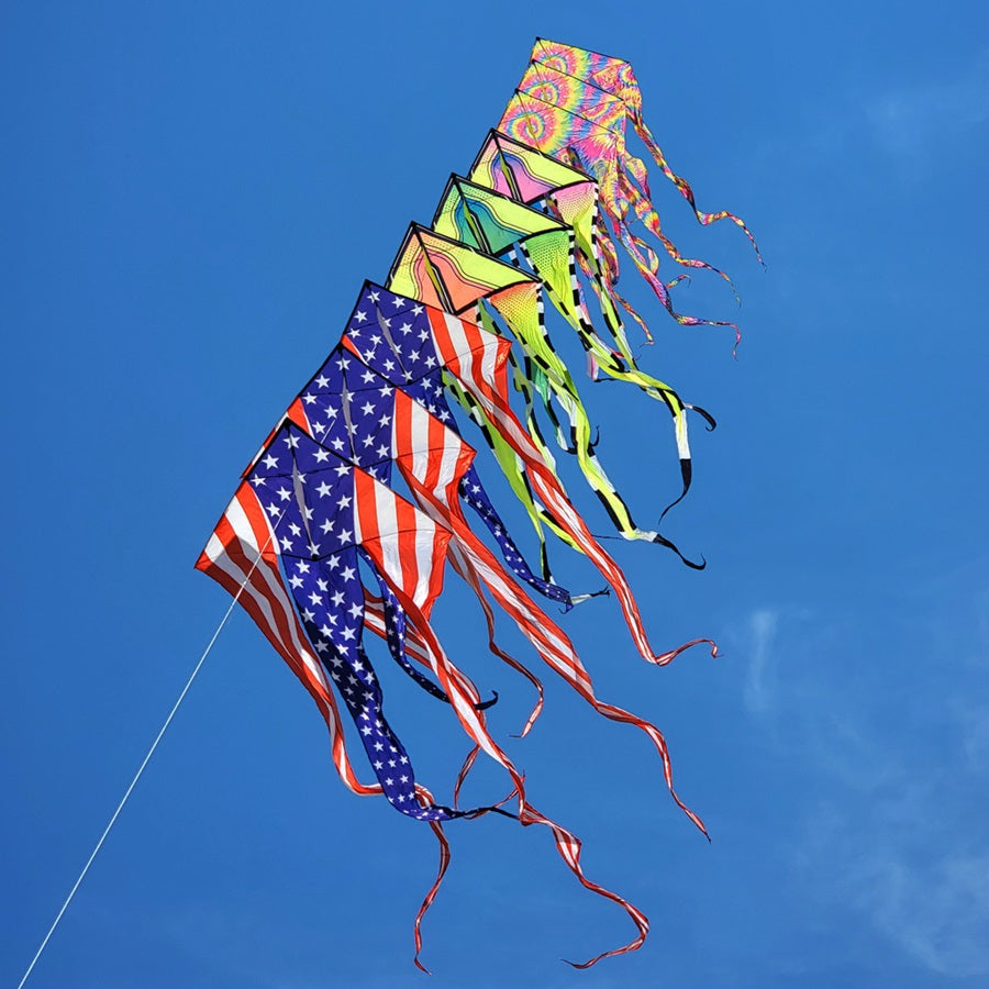 Colorful stack of kites against a clear blue sky