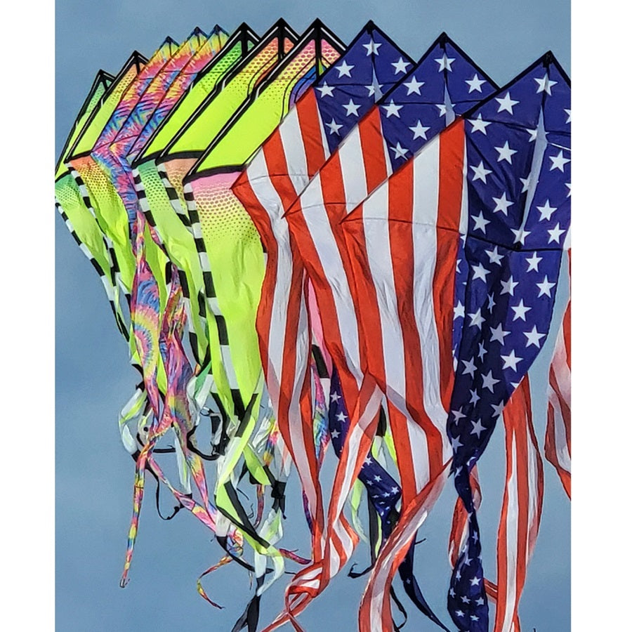 Colorful kites, including an American flag design, against a clear blue sky.