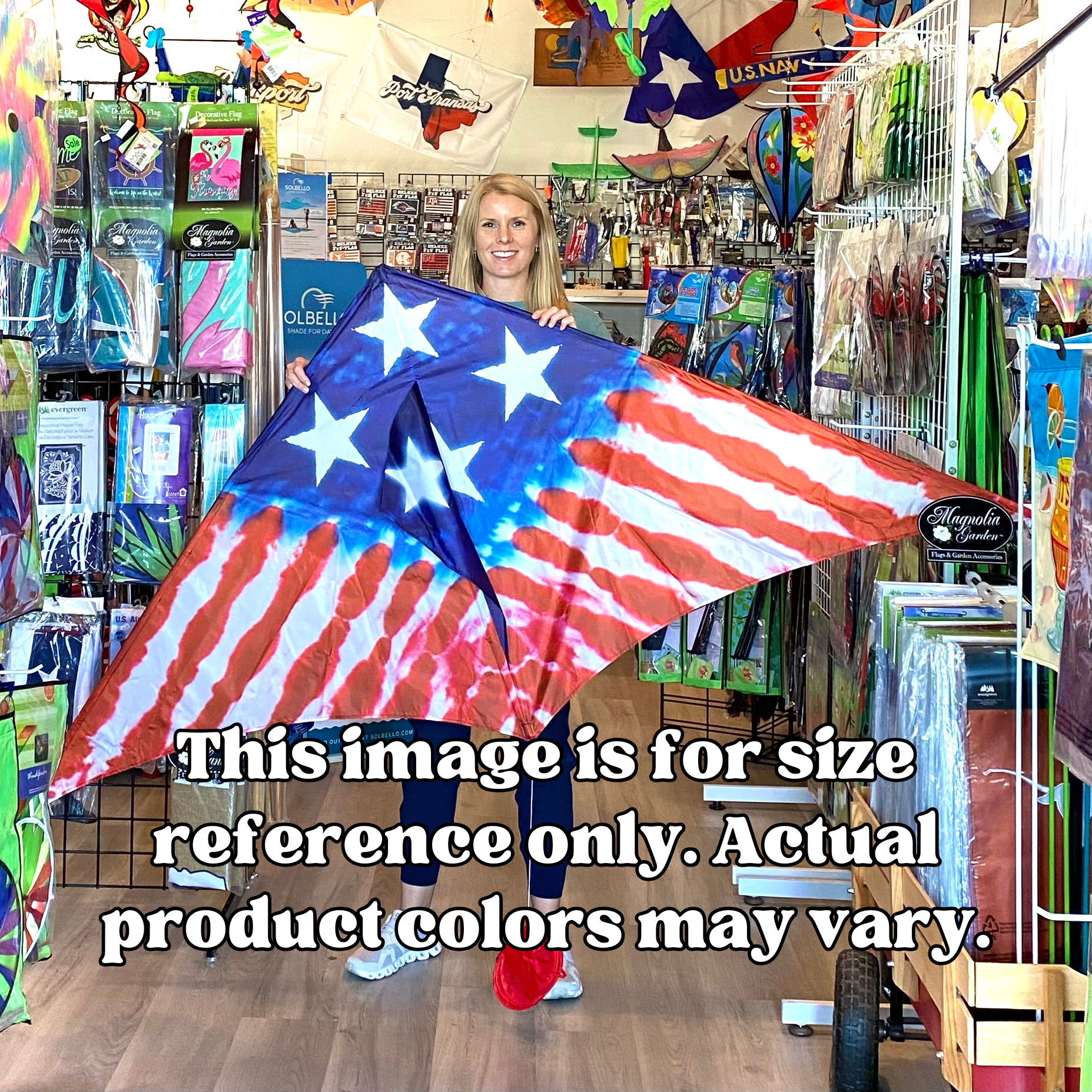 Person holding a large American flag kite in a store with various products on shelves.