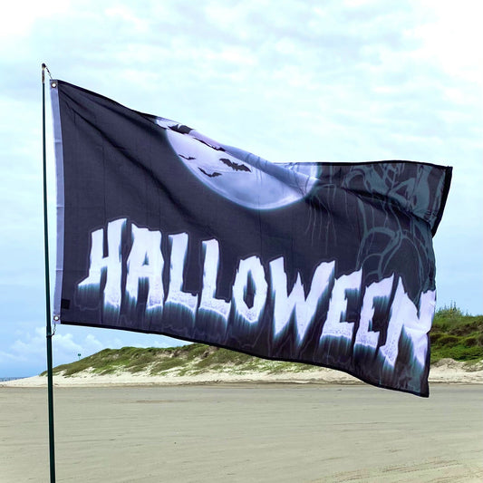 Halloween-themed flag with a ghost design on a beach