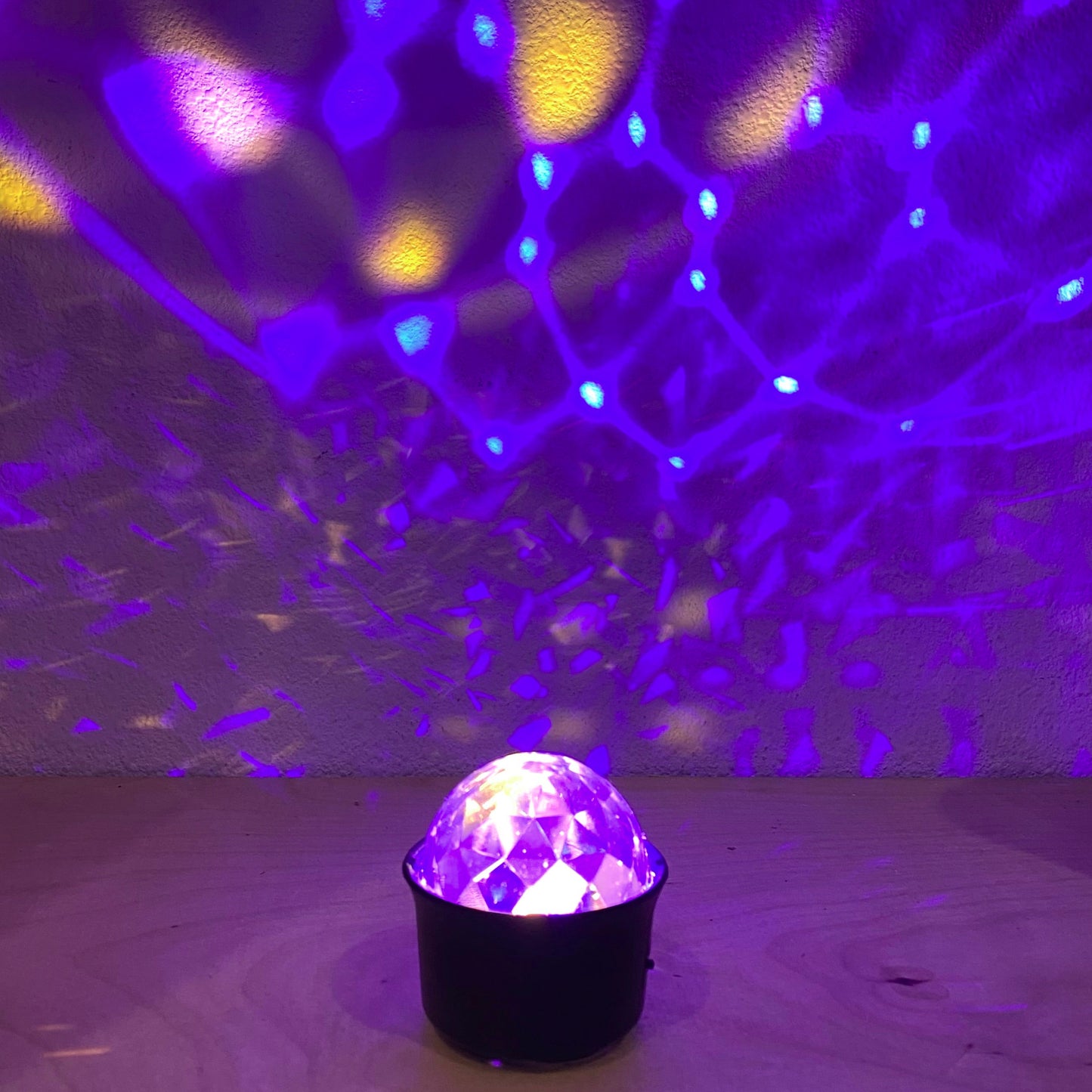Disco ball emitting colorful light patterns on a reflective surface
