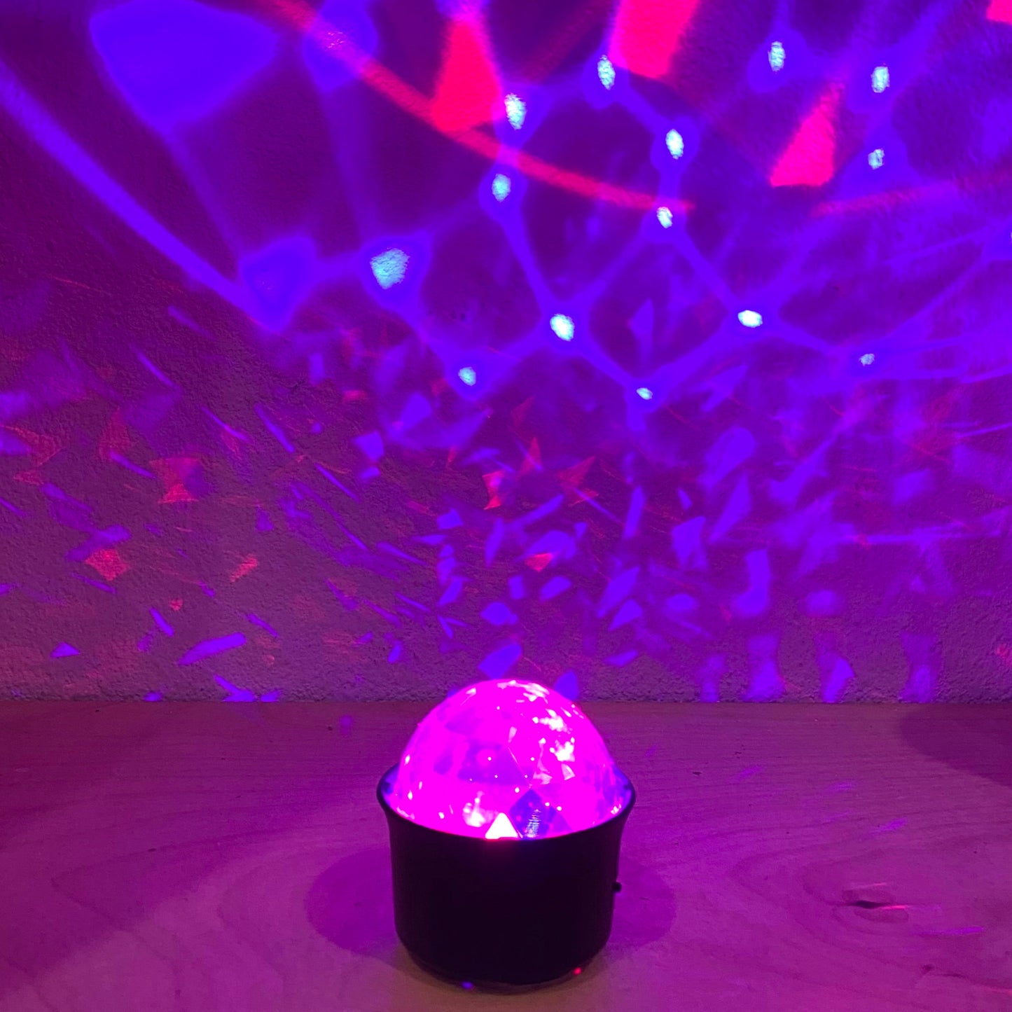 Colorful disco ball with light patterns on a wooden floor