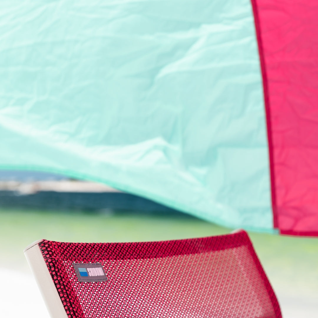 Close-up of a mint and berry Shibumi chair under a mint and berry Shibumi Shade. 