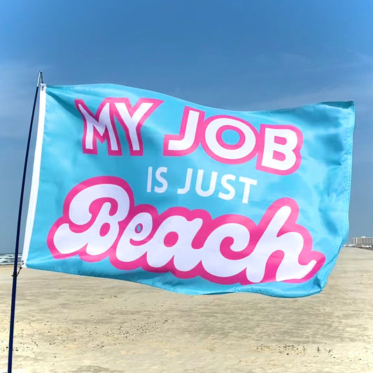 Flag with 'My Job is Just Beach' text on a beach