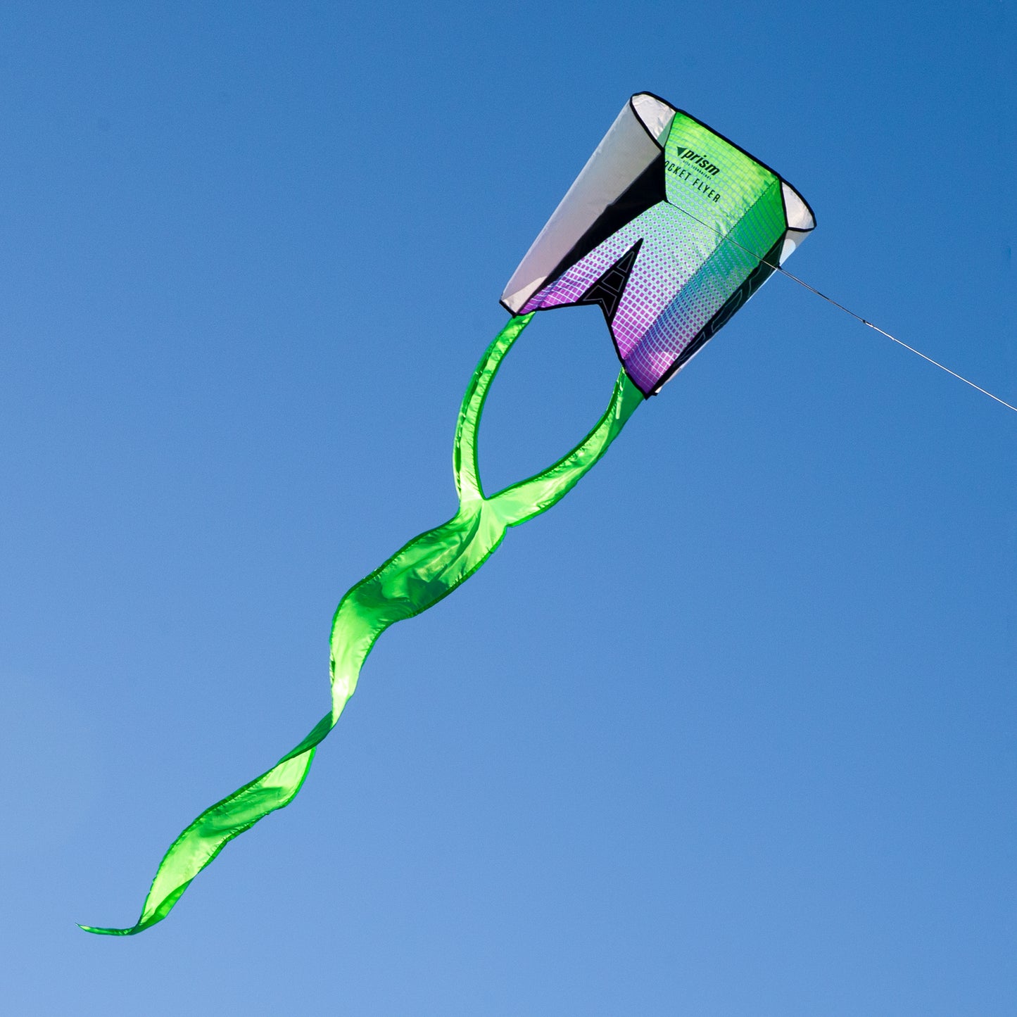 Green kite with a colorful tail against a clear blue sky