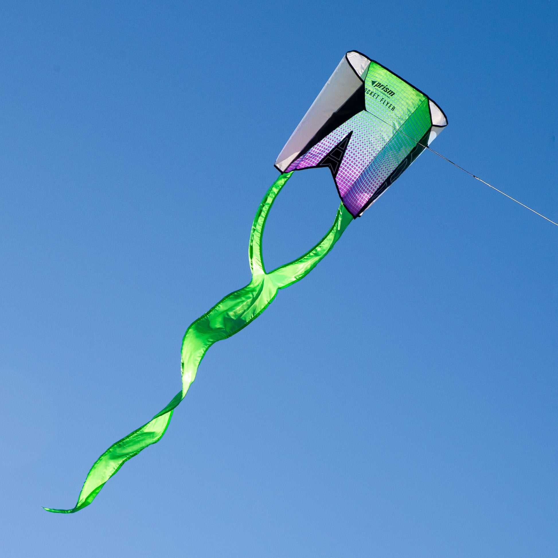 Green kite with a colorful tail against a clear blue sky
