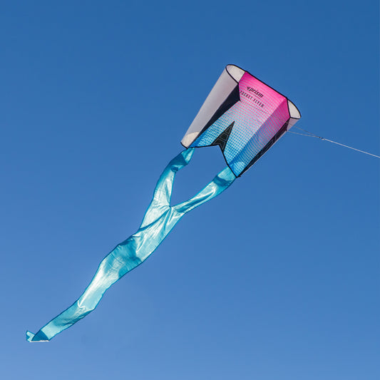 Colorful kite with a pink top and blue tail against a clear blue sky