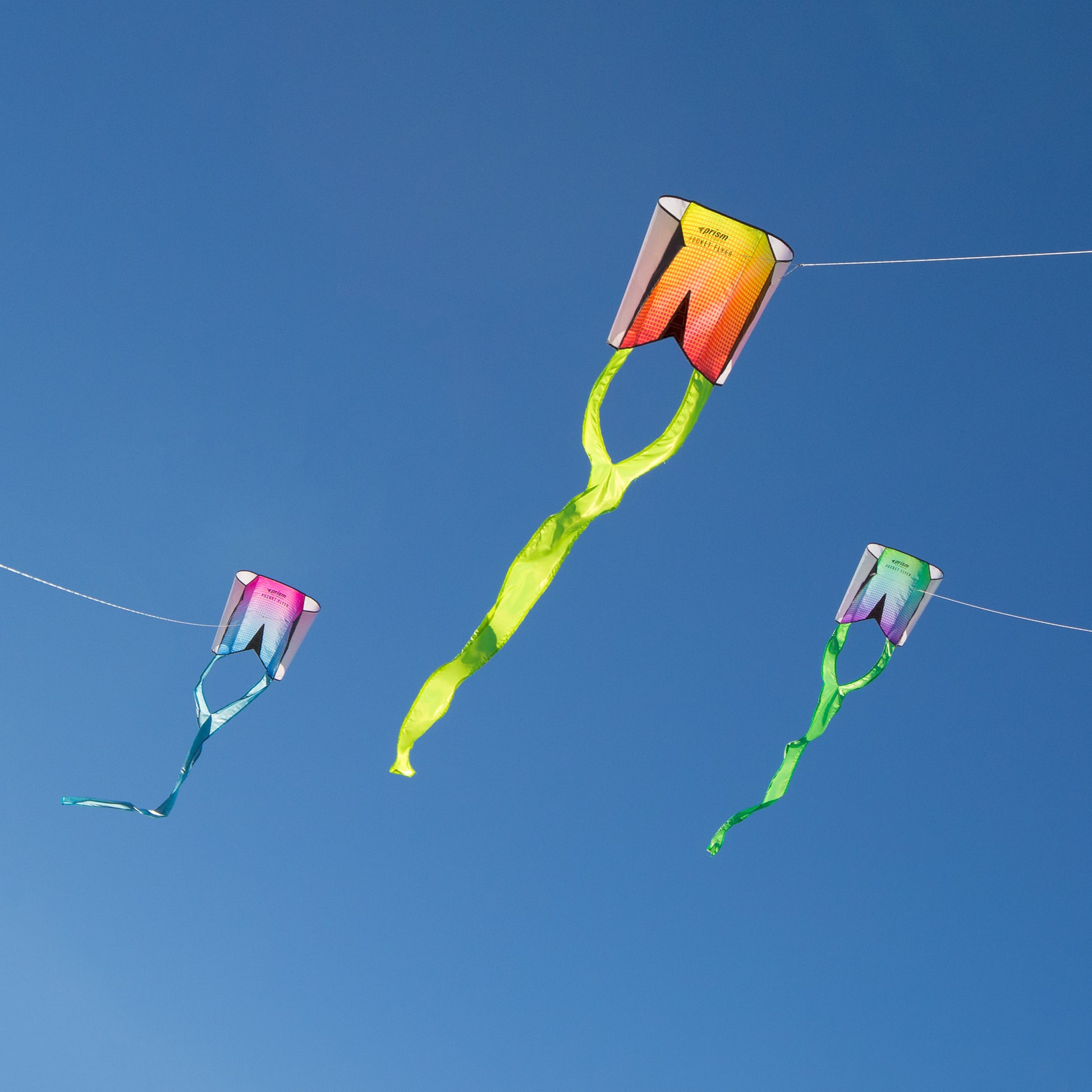 Three colorful kites flying against a clear blue sky.