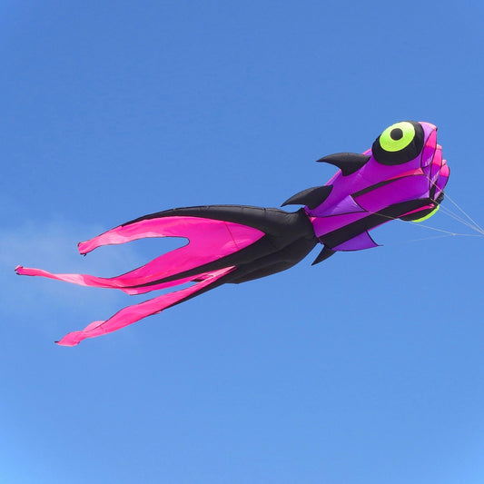 Colorful kite shaped like a goldfish flying against a clear blue sky