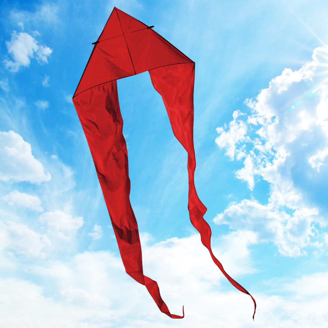 Red kite with a long tail against a blue sky with clouds