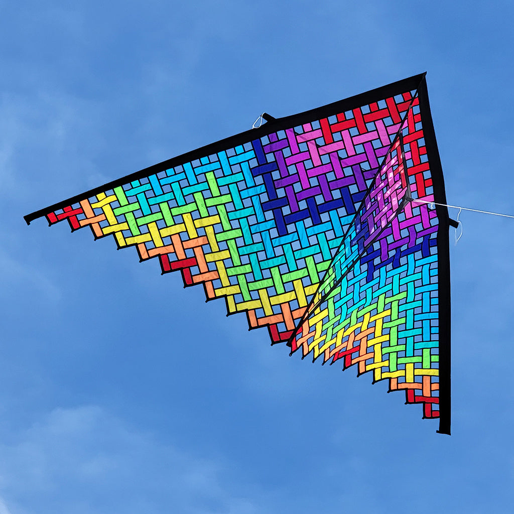 Colorful geometric-patterned kite against a blue sky