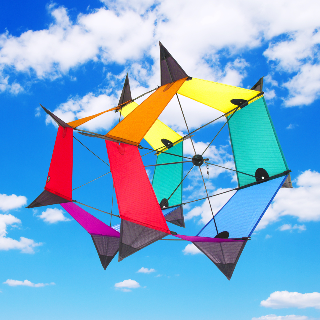 Colorful kite with geometric design against a blue sky with clouds