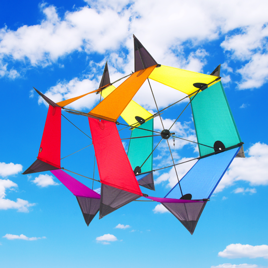 Colorful kite with geometric design against a blue sky with clouds