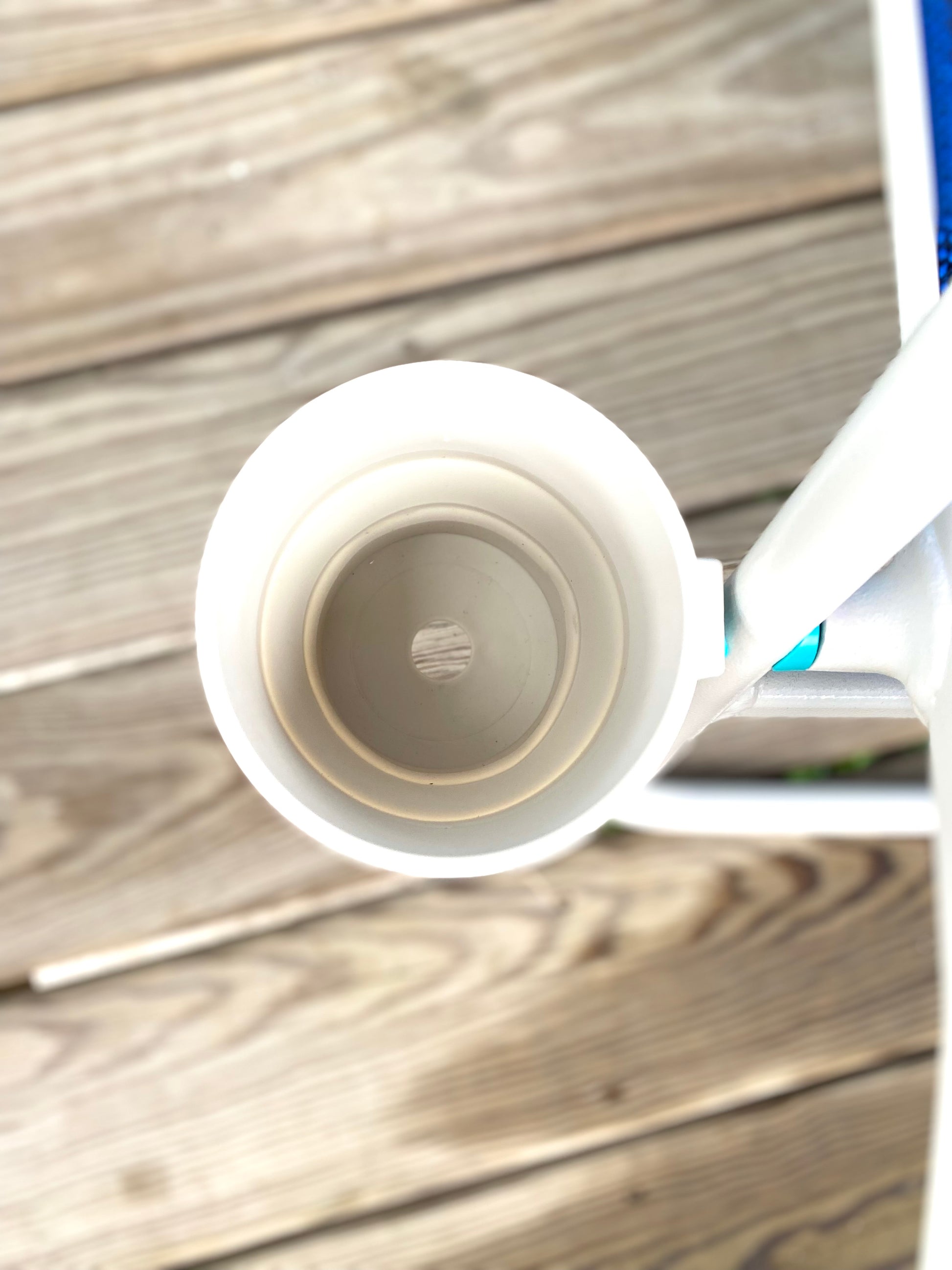 Close-up of a white cup holder with a logo on a wooden surface