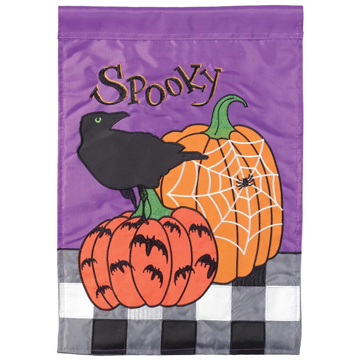 A vertical Halloween garden flag with a purple top section, black cursive 'Spooky' text, a black crow, two orange pumpkins, white spiderwebs, and a black-and-white buffalo plaid bottom border.