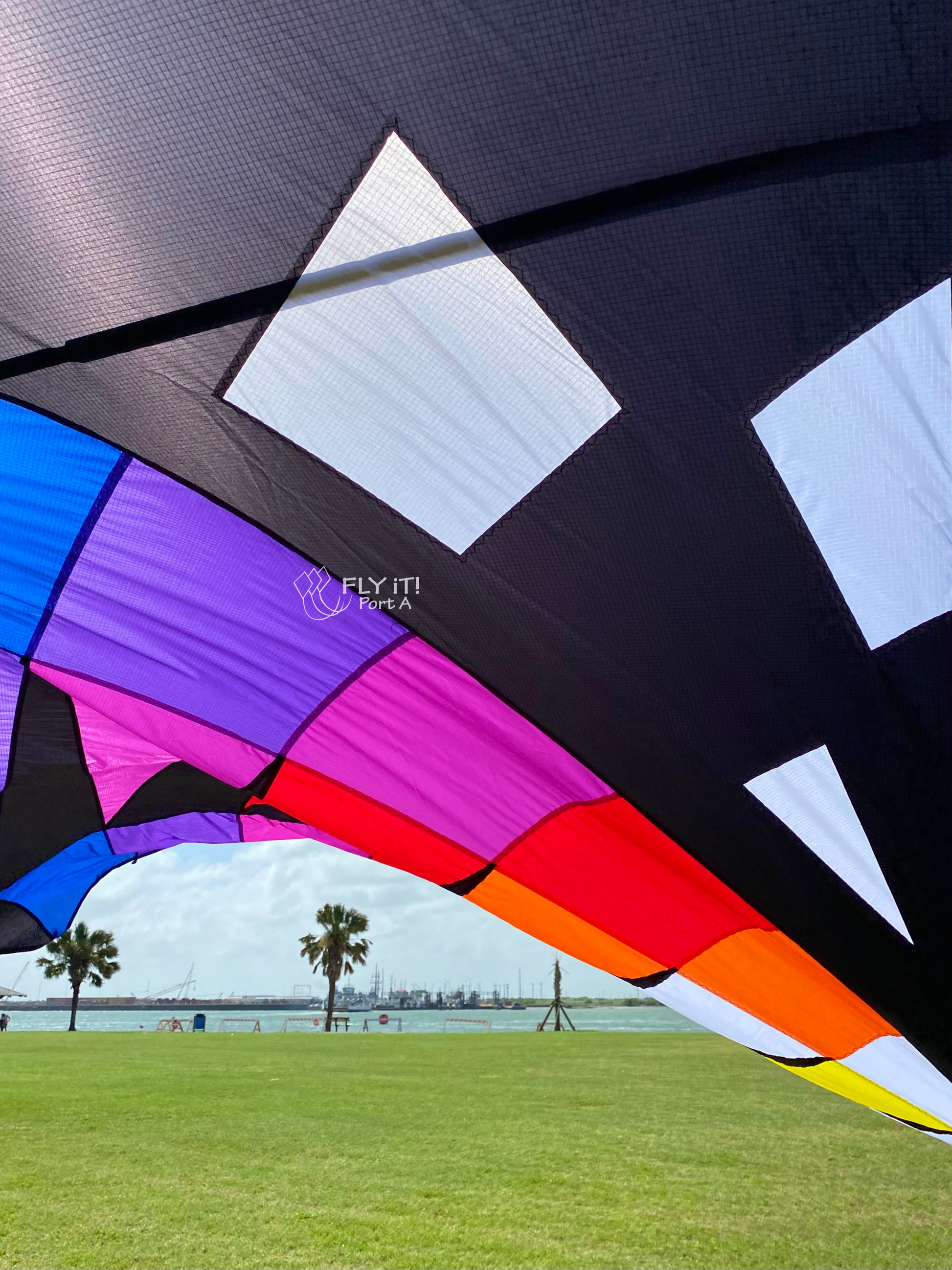 Colorful kite strings with colored beads against a clear blue sky.
