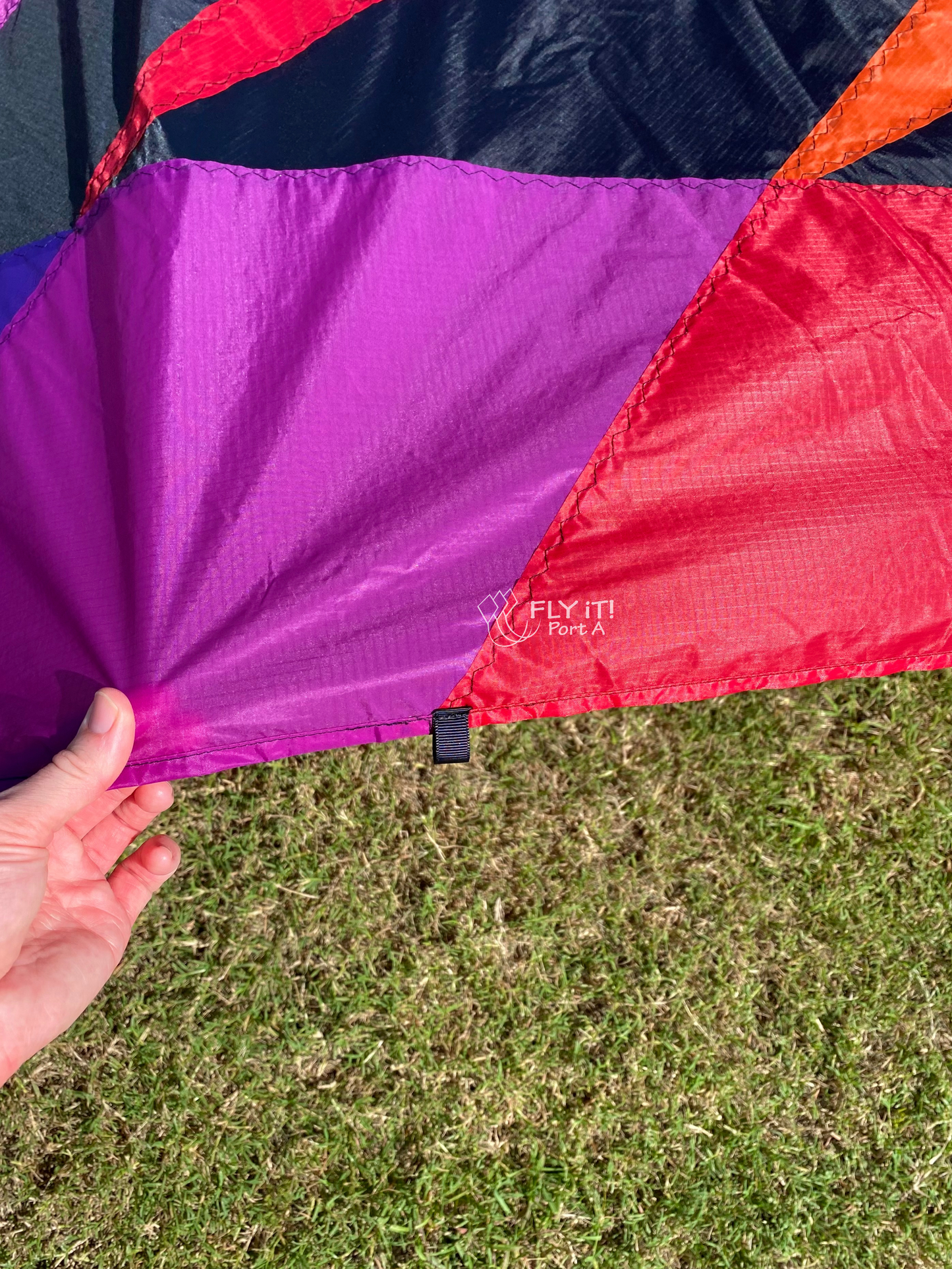 Close up of a colorful kite with grass in the background. 