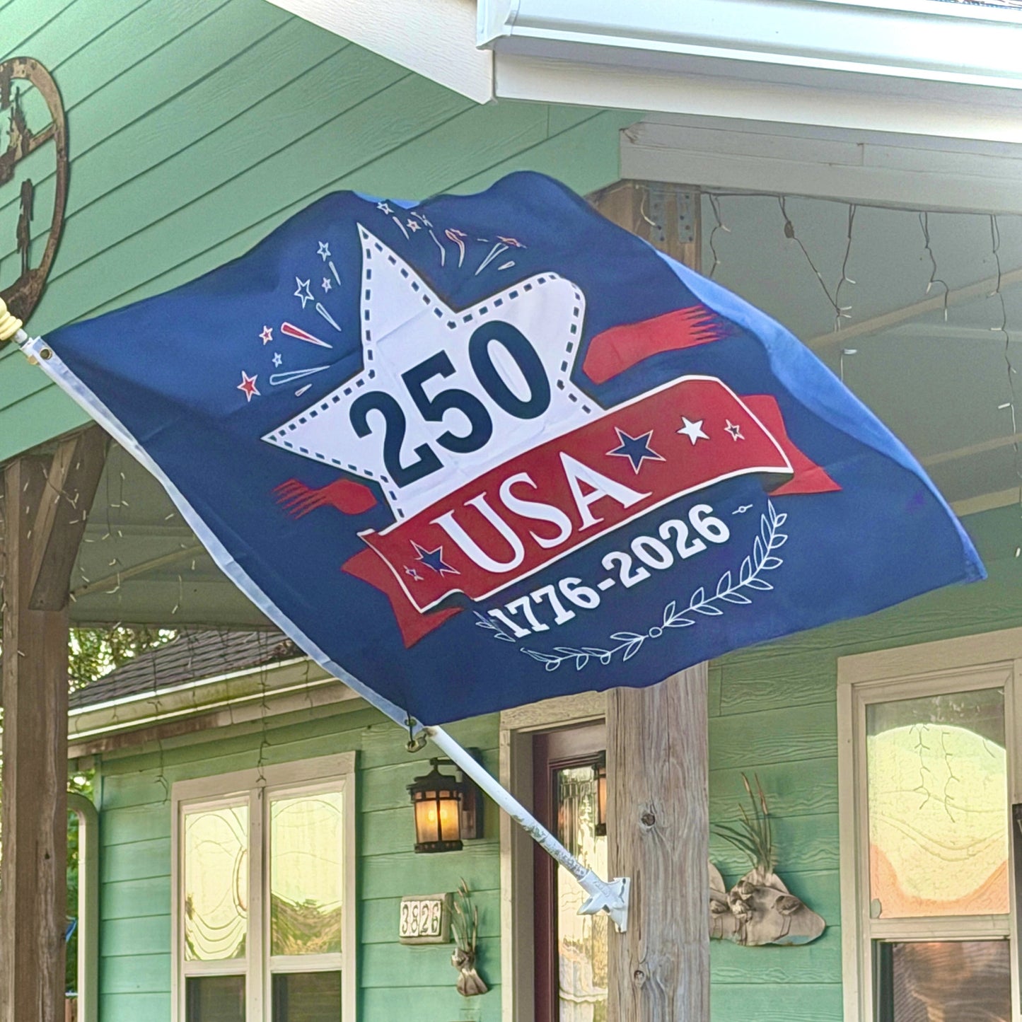 Decorative flag with '250 USA 1776-2026' on a porch
