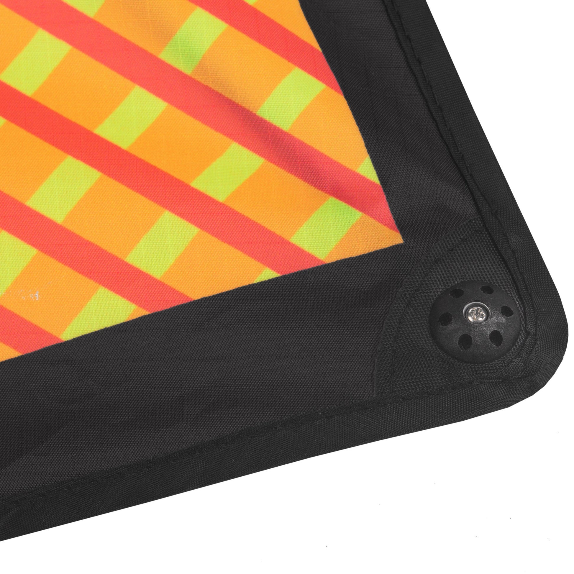 Corner of a colorful kite with black frame and control handle on a white background