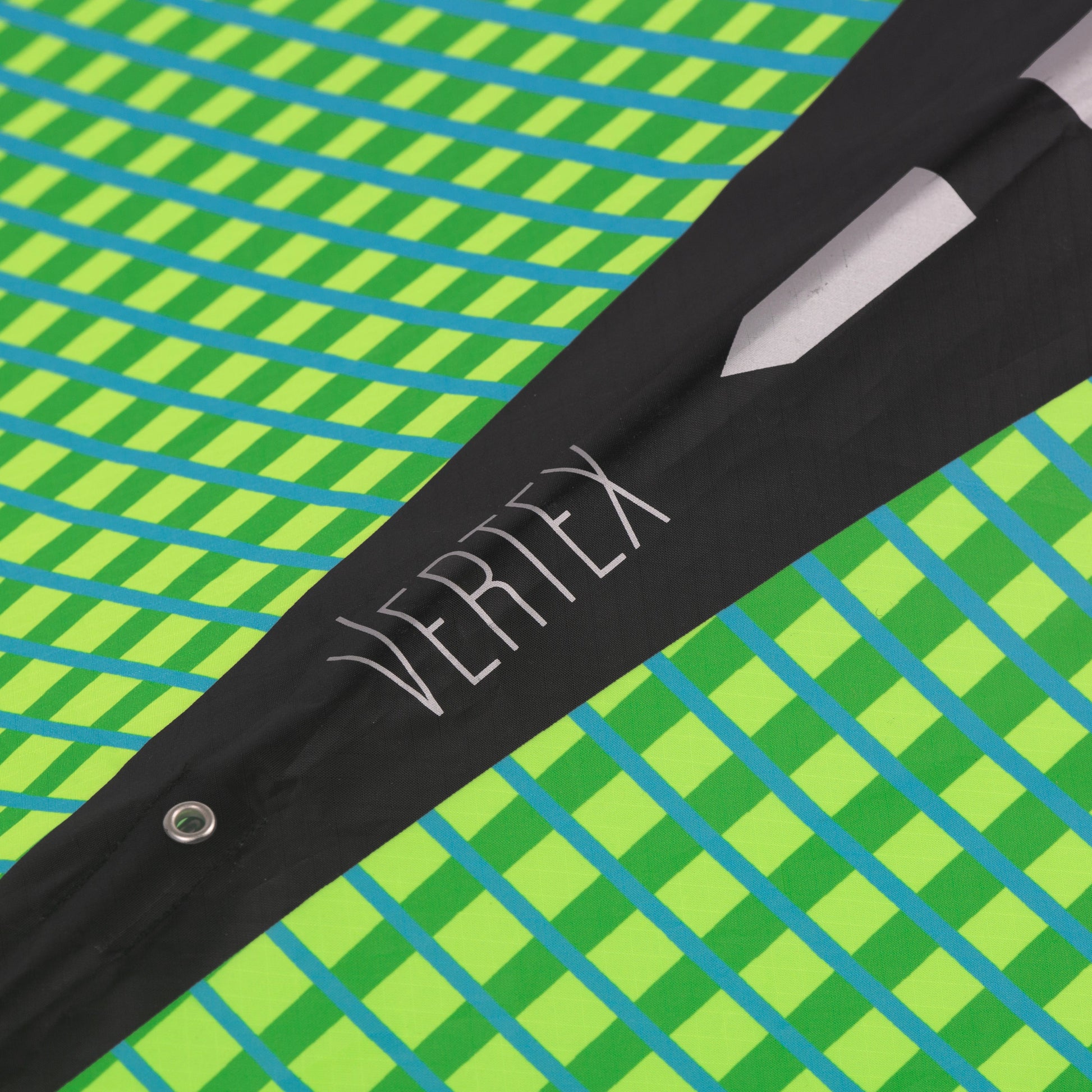 Close up of Aurora Vertex diamond kite with 'Vertex' branding on a green and blue checkered background